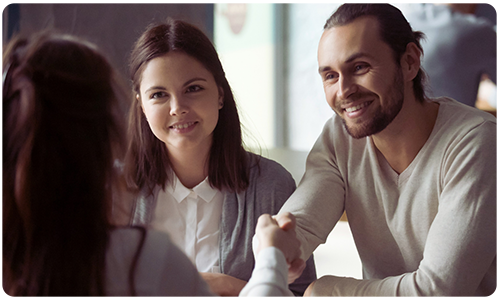 A photo of a couple meeting and shaking hands with a professional.