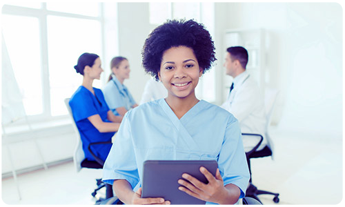 A photo of a smiling nurse holding a tablet.